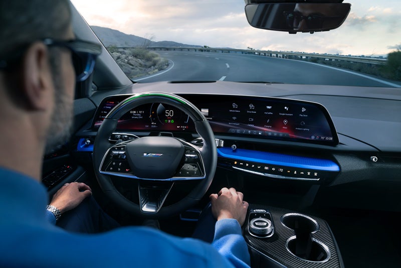 Front View of the 2026 OPTIQ-V Driving Through the Dusk Utilizing its Headlights | Sheboygan Cadillac in Sheboygan WI